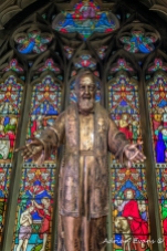 Statue and ancient stained glass window UK