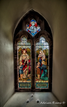 stained glass window and three candles north Wales, UK