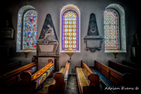 Three stained glass windows in an ancient Welsh church, north Wales UK
